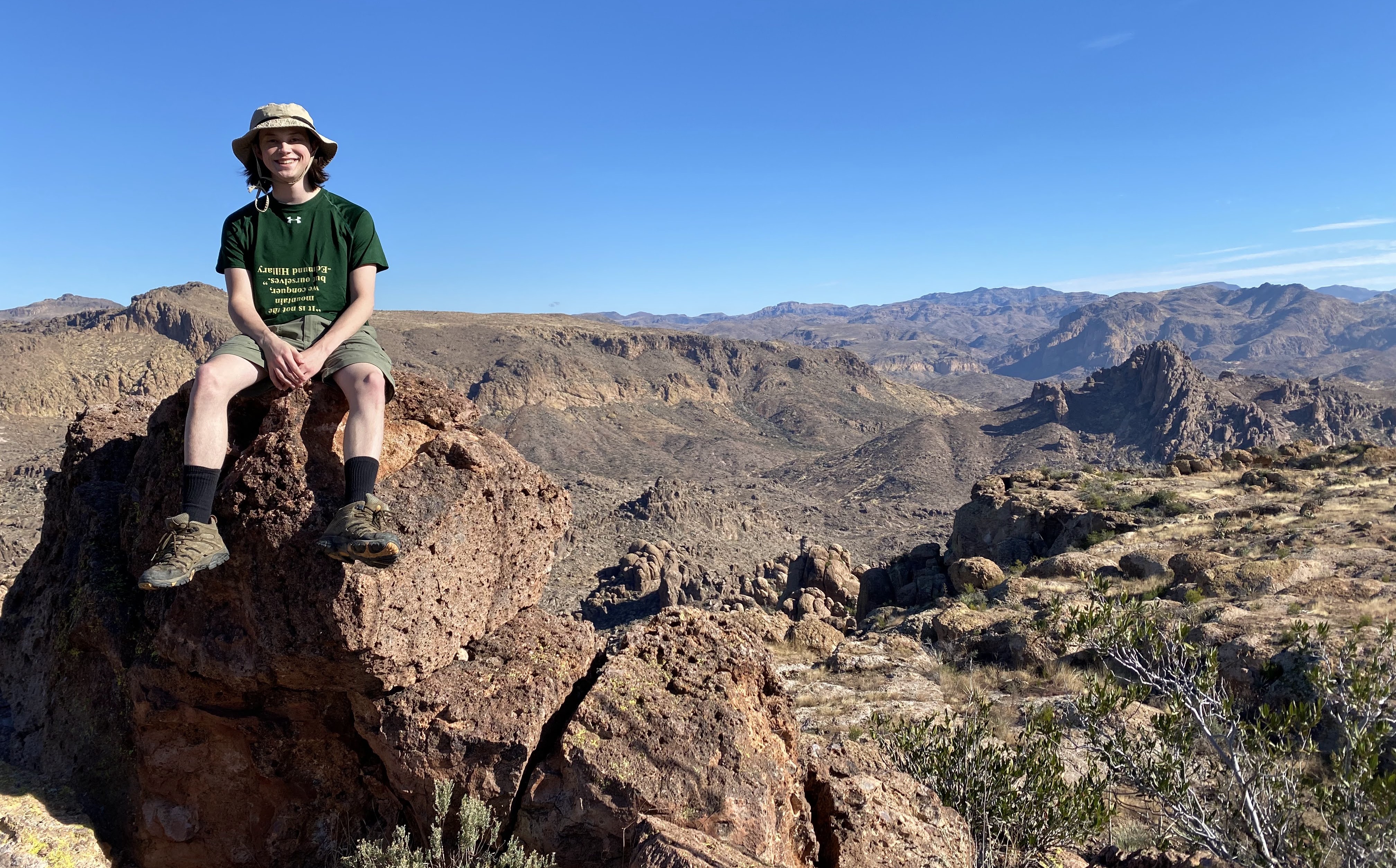 Image of Graham sitting on a rock by the edge of a large valley